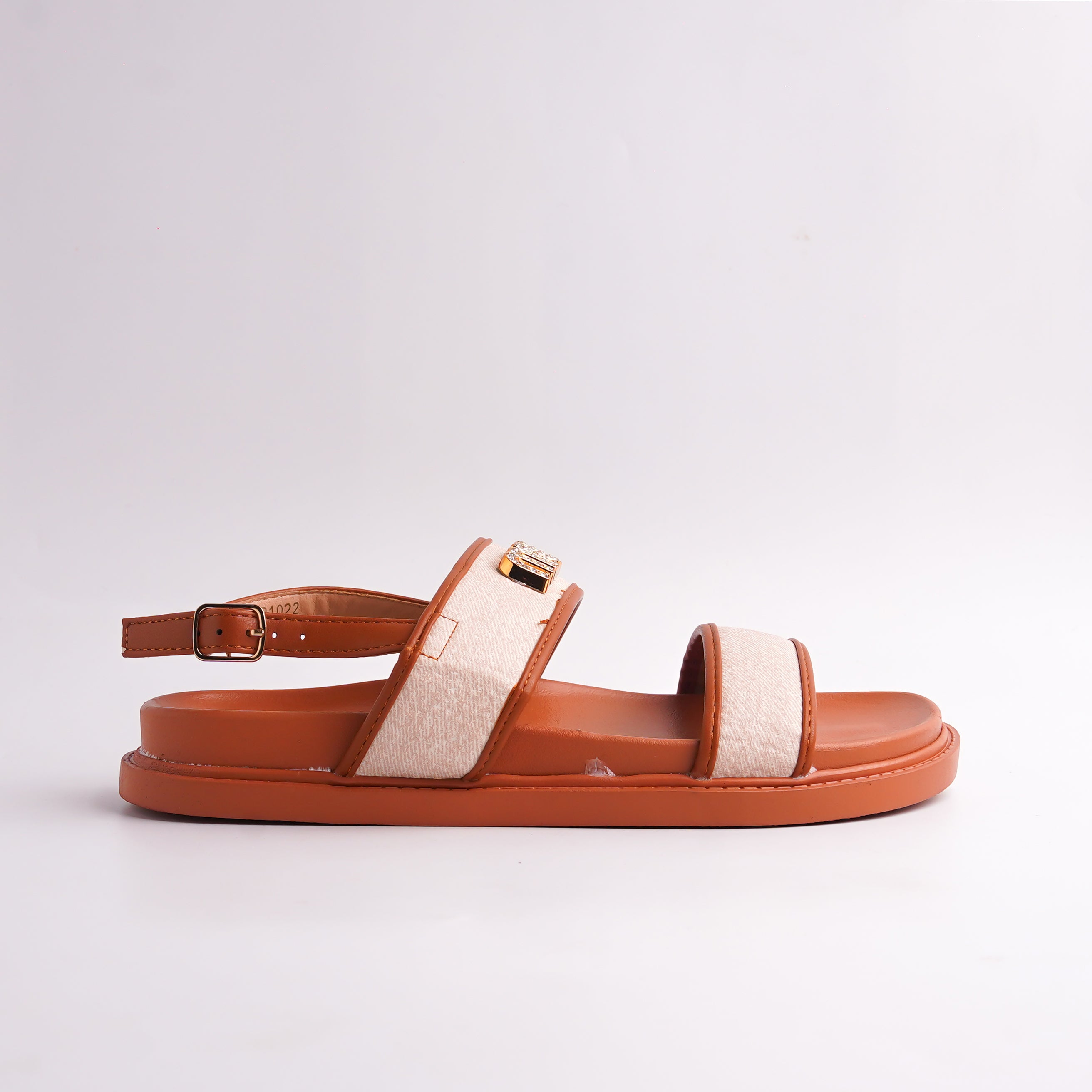 Brown sandal with beige strap on a light gray background