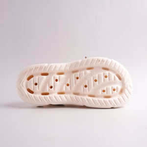 Close-up of a white shoe sole with a textured pattern on a light gray background