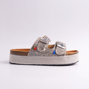 Silver sandal with colorful embellishments on a white background