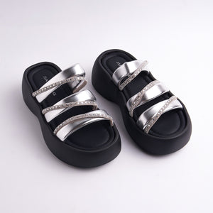 Black sandals with silver straps on a white background