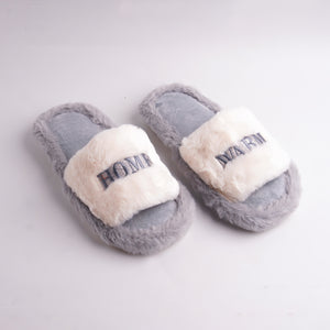 Alayna Fashion pair of Gray Faux Fur Slides with white embroidered 'HOME WARM' cross-straps, cozy slippers.