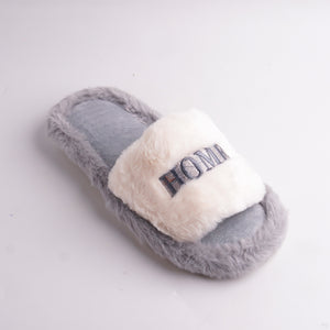 Close-up of Gray Fur Slide showing the 'HOME' embroidery on the plush strap, comfortable indoor slipper.