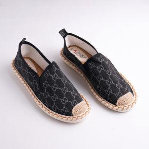 Black espadrille shoes with a pattern on a white background