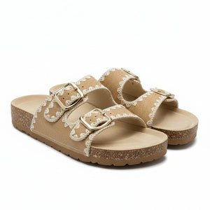 Pair of beige sandals with white lace details on a white background