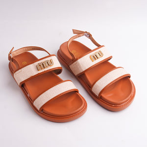 Pair of brown sandals with beige straps on a white background
