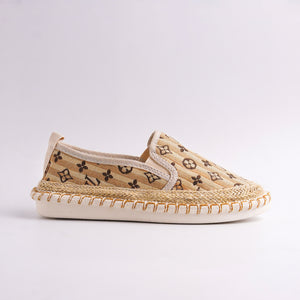 Beige slip-on shoe with patterned design on a light gray background