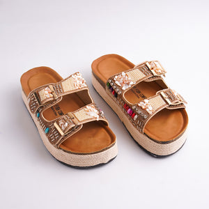 Pair of embellished sandals on a white background