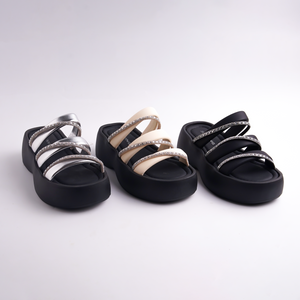 Three pairs of black sandals with decorative straps on a white background