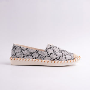 Decorative flat shoes with a patterned design on a light gray background