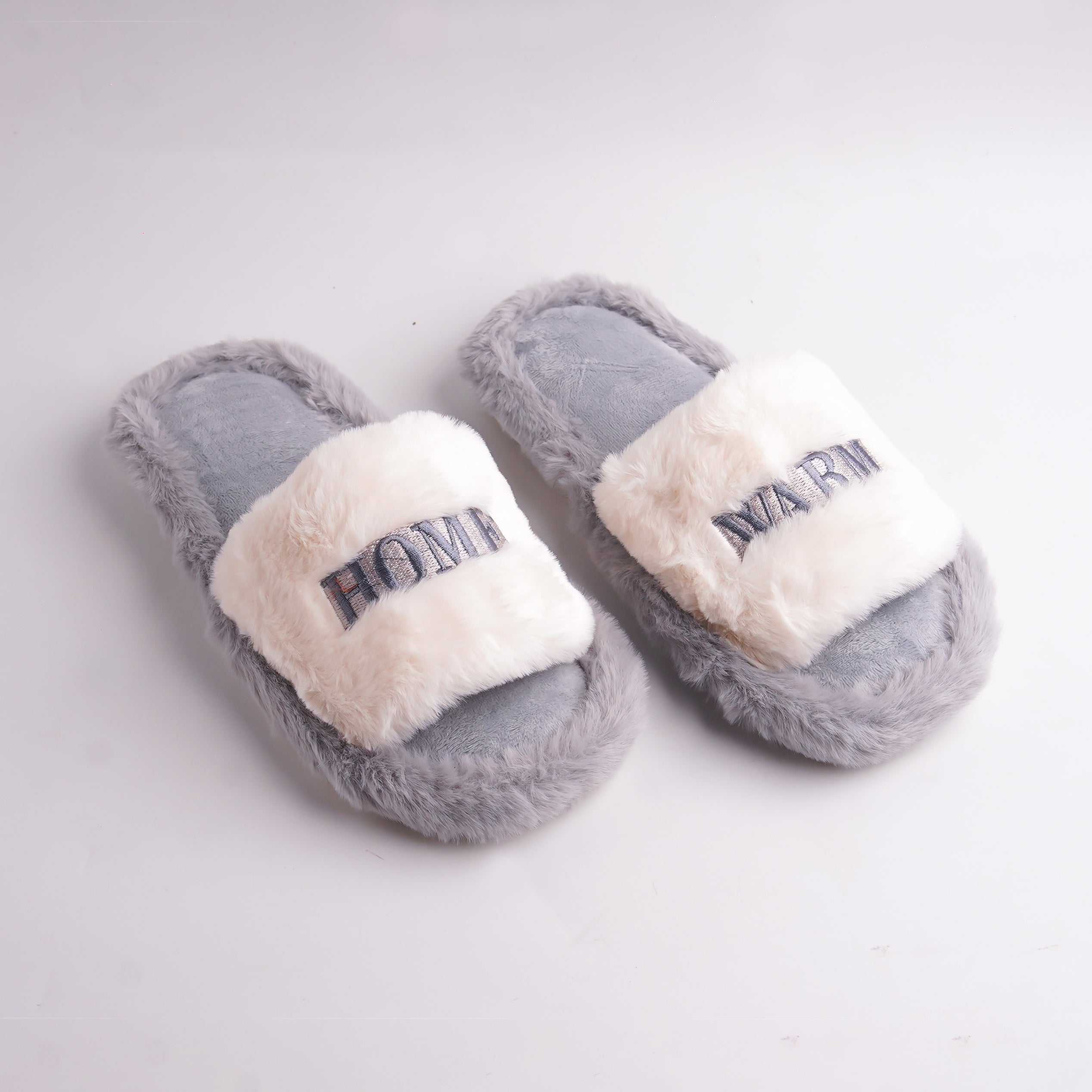 Alayna Fashion pair of Gray Faux Fur Slides with white embroidered 'HOME WARM' cross-straps, cozy slippers.