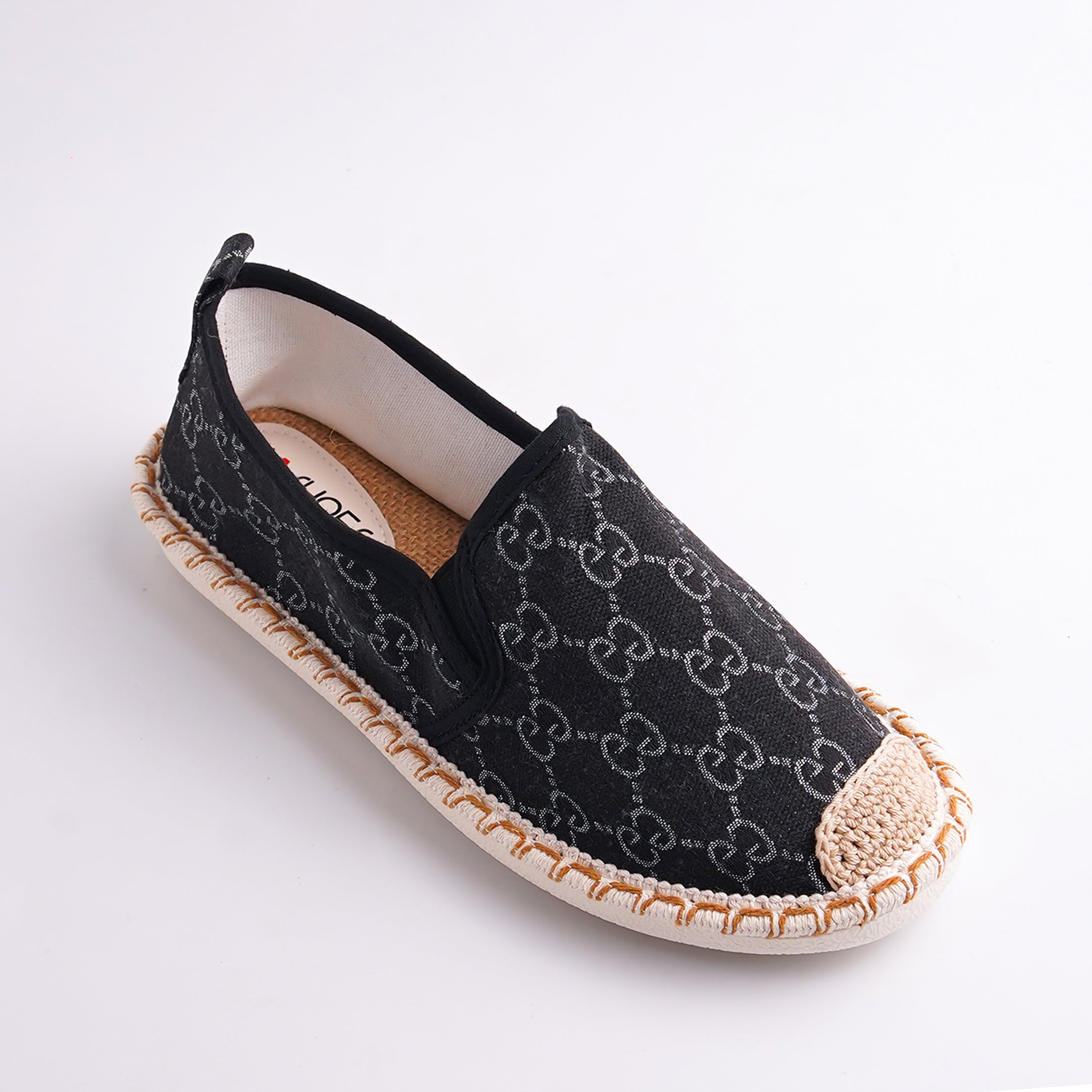 Black espadrille shoe with a pattern on a white background