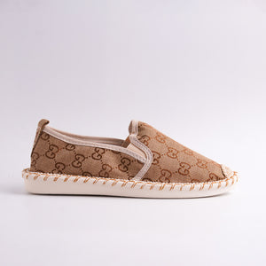 Beige slip-on shoe with patterned design on a light gray background