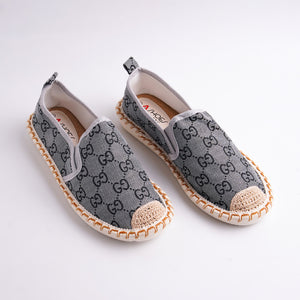 Pair of gray slip-on shoes with a pattern on a white background
