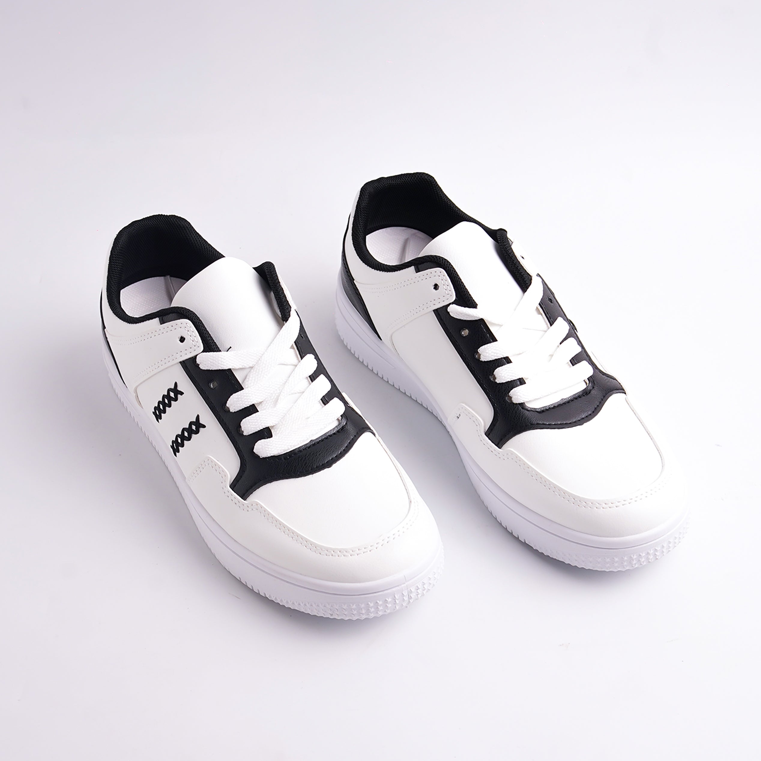 White sneakers with black accents on a light gray background