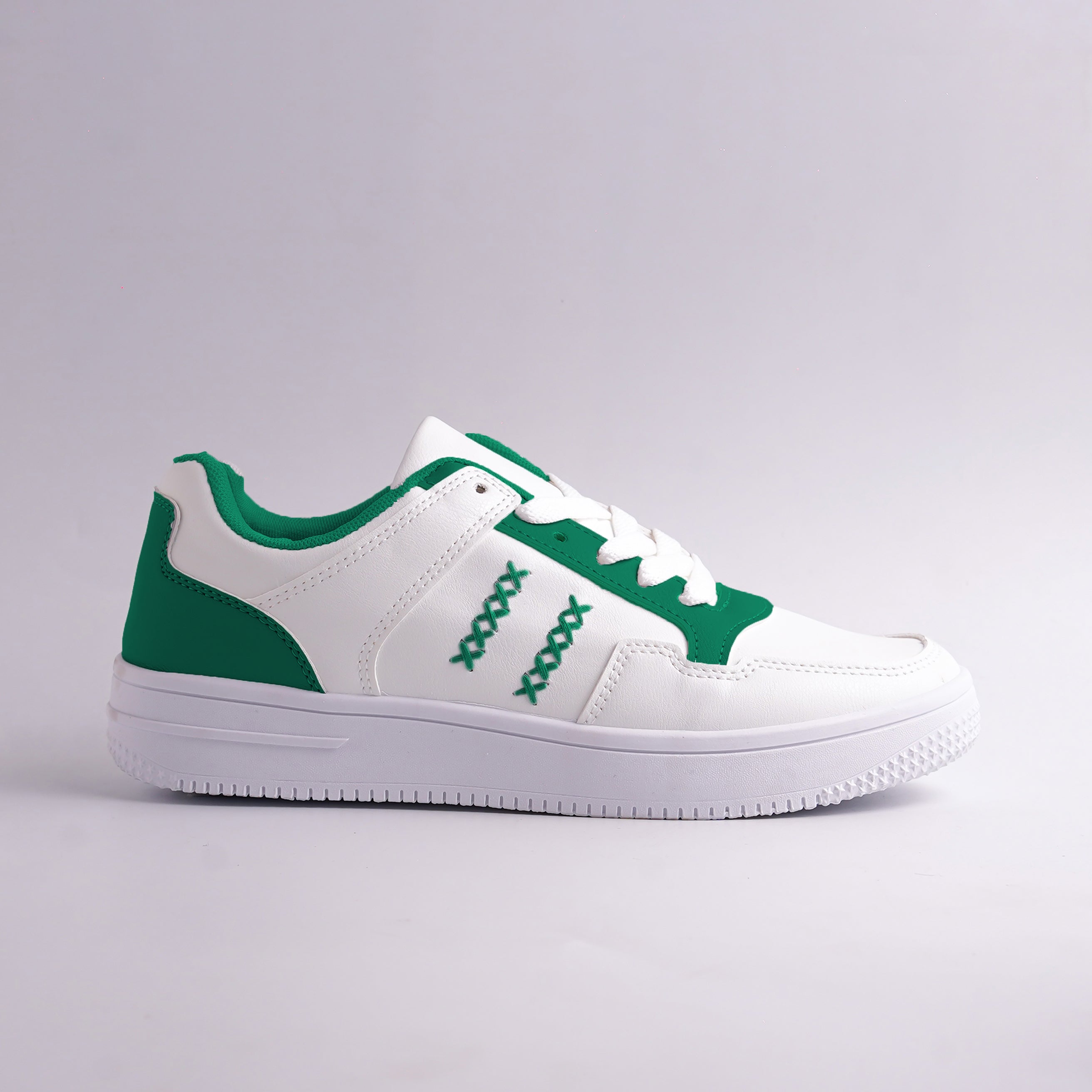 White sneaker with green accents on a gray background