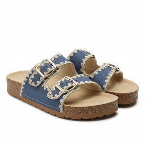 Pair of blue sandals with gold buckles on a white background