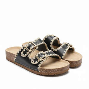 Black sandals with decorative straps on a white background