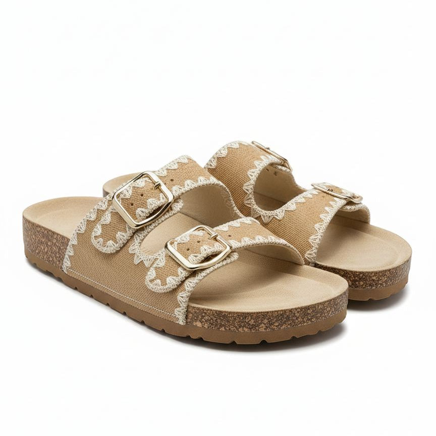 Pair of beige sandals with white lace details on a white background