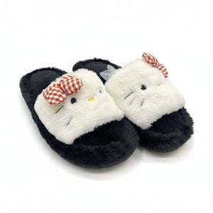 Pair of black slippers with white fur and red checkered bow on a white background